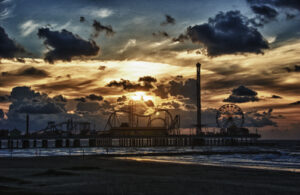 Pleasure Pier's silhouette against a sunset sky in a photograph by Ken Osborne