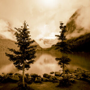 Sepia-toned dawn over a tranquil lake with misty mountain backdrop