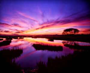 Vivid sunset colors painting the sky and reflecting on the water in Galveston