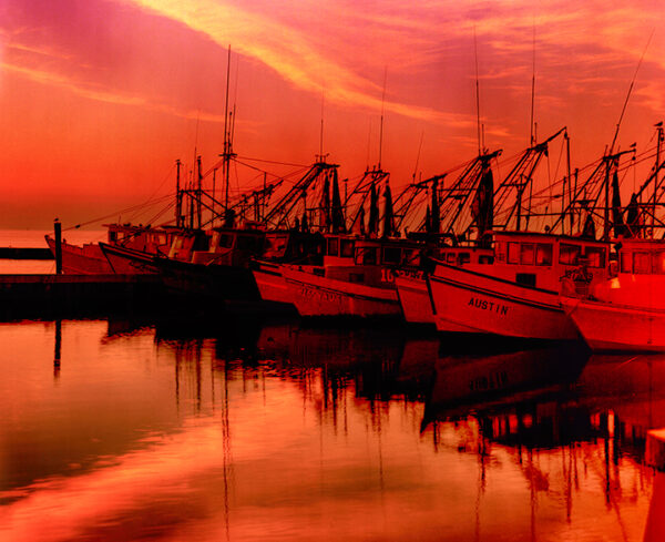 Rockport harbor at sunset with vibrant reflections by Ken Osborne