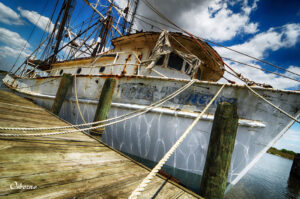 Weathered shrimpboat moored under a dynamic sky