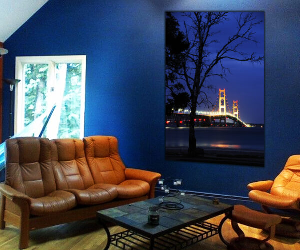 "Twilight Vigil at Mackinac Bridge" photograph displayed in a cozy room with blue walls and leather furniture