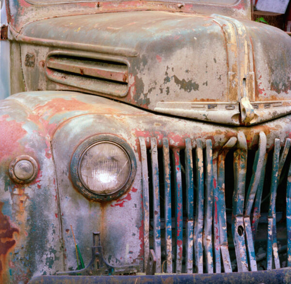 Close-up of a vintage Ford truck with peeling paint, photographed by Ken Osborne