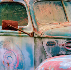 Detailed close-up of a vintage Ford truck's weathered side mirror and door by Ken Osborne